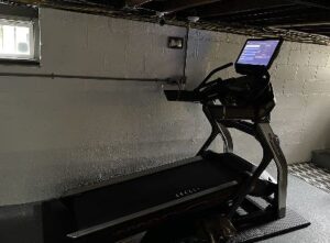 Bowflex treadmill set on a high incline level on a rubber floor matt